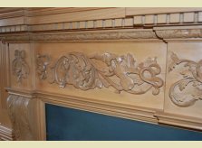 Close-up of specially comissioned mantelpiece showing hand carved musical instruments